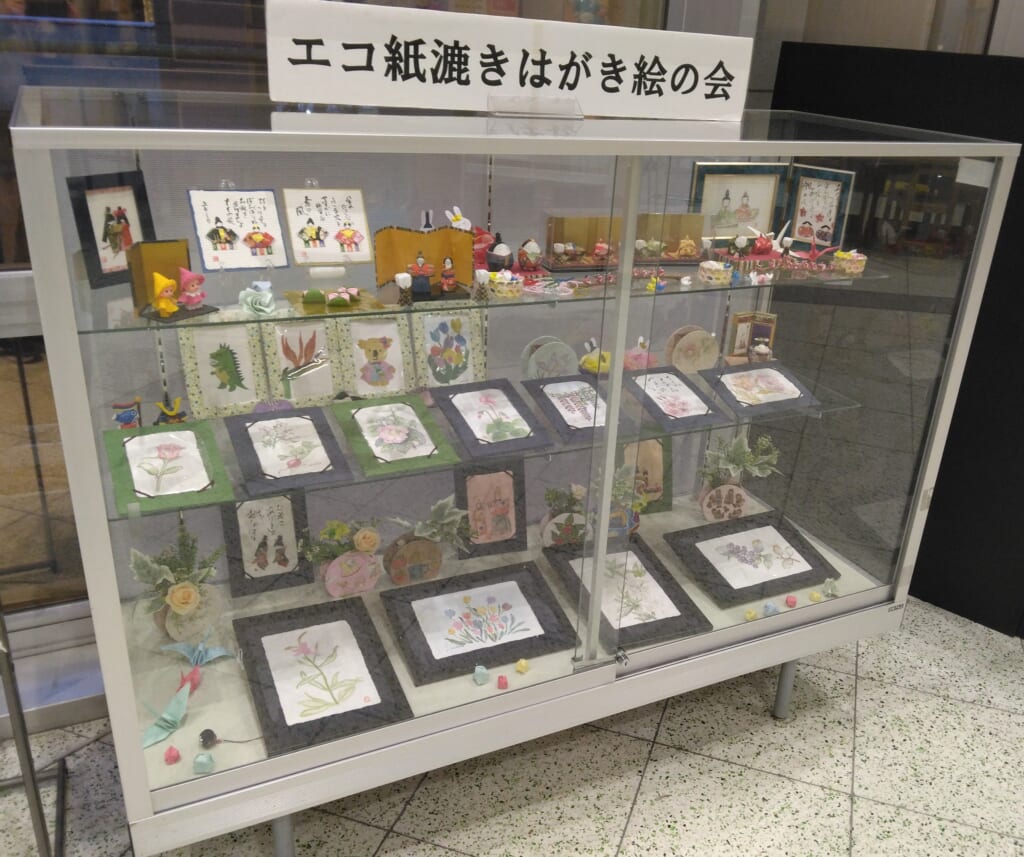 【1階ガラスケース展示】登録環境団体「エコ紙漉きはがき絵の会」